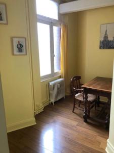 a room with a table and chairs and a window at Spacieux 80 m2 Cœur de Vichy proche des Thermes in Vichy
