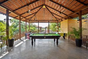 a pool table in the middle of a room with a roof at The Vanveda Resort By Nirvana in Sasan Gir