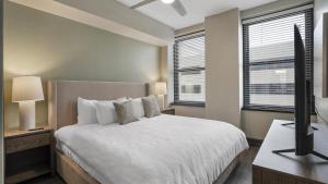 una camera con letto e scrivania con TV di Landing Modern Apartment with Amazing Amenities (ID8404X53) a Mobile