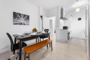 a kitchen and dining room with a table and chairs at Luxury Holiday Home near Kings Cross Sleep 12 SP7 in London