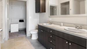 a bathroom with two sinks and a toilet and a mirror at Landing Modern Apartment with Amazing Amenities (ID2205) in Baltimore