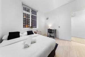 a white bedroom with a large bed and a window at Luxury Holiday Home near Kings Cross Sleep 12 SP7 in London