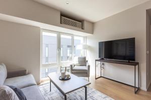 ein Wohnzimmer mit einem Sofa, einem TV und einem Tisch in der Unterkunft Landing Modern Apartment with Amazing Amenities (ID4754X66) in Portland
