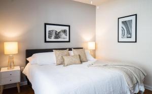 達拉姆的住宿－Landing Modern Apartment with Amazing Amenities (ID7301)，卧室配有白色的床和墙上的两张照片