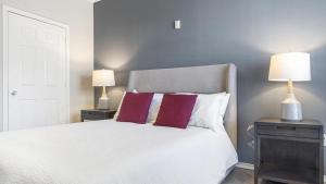 um quarto com uma cama branca e 2 candeeiros em Landing Modern Apartment with Amazing Amenities (ID8377X83) em Grapevine