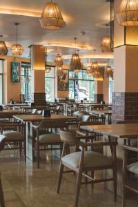 a restaurant with wooden tables and chairs and lights at María Isabel Colima in Colima