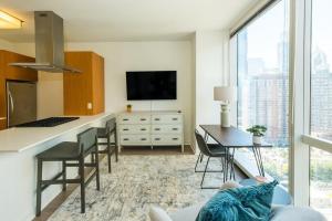 a living room with a kitchen with a large window at Landing Modern Apartment with Amazing Amenities (ID634) in Chicago