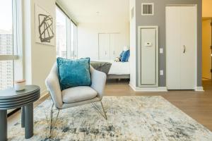 - un salon avec une chaise et un lit dans l'établissement Landing Modern Apartment with Amazing Amenities (ID634), à Chicago
