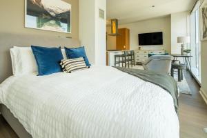 1 dormitorio con 1 cama blanca grande con almohadas azules en Landing Modern Apartment with Amazing Amenities (ID634) en Chicago