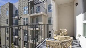 - un balcon avec deux chaises et un bâtiment dans l'établissement Landing Modern Apartment with Amazing Amenities (ID8777X46), à San Diego