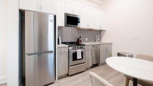 a kitchen with a stainless steel refrigerator and a table at Landing Modern Apartment with Amazing Amenities (ID5790X41) in Birmingham