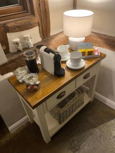 a table with a coffee maker on top of it at Millie's Cottage in Finchingfield