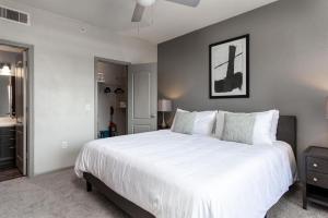 een slaapkamer met een groot bed met witte lakens bij Landing Modern Apartment with Amazing Amenities (ID4174X27) in Austin