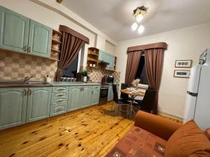 uma cozinha com armários verdes e piso em madeira em Viesu māja V.Seiles ielā em Rezekne