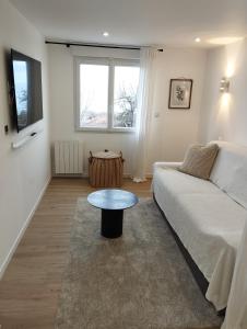 a living room with a couch and a table at Au coucher du lac in Publier