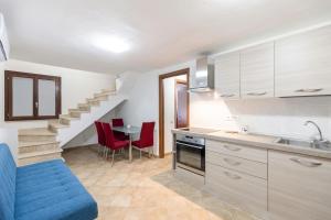 a kitchen with a staircase and a table with red chairs at Villa del Moro, FREE WIFI, 300mt from Sinzias' Beach in Costa Rei