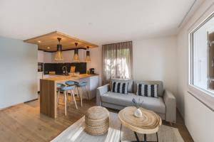 a living room with a couch and a table at Bijou Lake Side Sauna - Panorama-Terrasse, Sauna und Seeblick in Leissigen