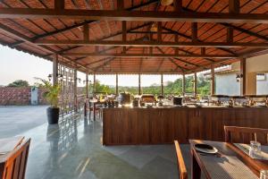a restaurant with a bar with tables and chairs at The Vanveda Resort By Nirvana in Sasan Gir
