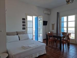 sypialnia z łóżkiem, stołem i krzesłami w obiekcie Panoramic View w Poros