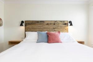 1 dormitorio con 1 cama blanca y 4 almohadas en Albermarle #202 Inn at Old Beach en Virginia Beach