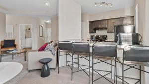 a kitchen and living room with a counter and chairs at Landing Modern Apartment with Amazing Amenities (ID1981X99) in Greensboro