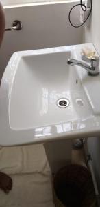 lavabo blanco con grifo en el baño en Villa Karel, en Riambel