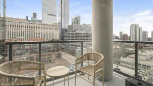 a balcony with a table and chairs and a view of a city at Landing Modern Apartment with Amazing Amenities (ID8152X03) in Chicago