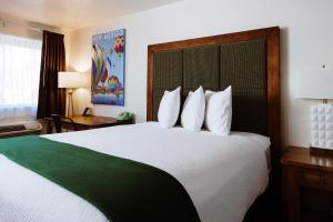 Habitación de hotel con cama grande con almohadas blancas en Taos Valley Lodge, en Taos