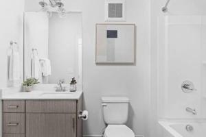 a white bathroom with a toilet and a sink at CozySuites Studio Apartment in Urban Indy in Indianapolis