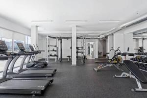 a gym with several treadmills and machines in it at CozySuites Studio Apartment in Urban Indy in Indianapolis