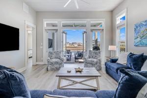 a living room with a blue couch and chairs and a table at The Water Way in Rockport