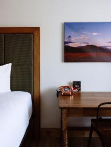 a bedroom with a bed and a wooden desk at Taos Valley Lodge in Taos