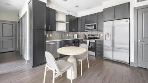 une cuisine avec des armoires noires, une table et des chaises dans l'établissement Landing Modern Apartment with Amazing Amenities (ID8595X86), à Parker