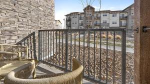 - un balcon avec 2 chaises, une clôture et des bâtiments dans l'établissement Landing Modern Apartment with Amazing Amenities (ID8595X86), à Parker