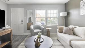 uma sala de estar com um sofá e uma mesa em Landing Modern Apartment with Amazing Amenities (ID1222X839) em High Point