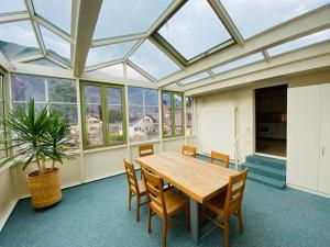 a conservatory with a table and chairs and a plant at Mountain Majesty Residences in Matten