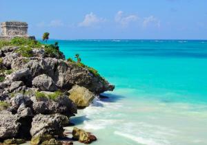 an island with a palm tree and the ocean at TOHO VILLA 4BED WITH POOL & JACUZZI in Tulum