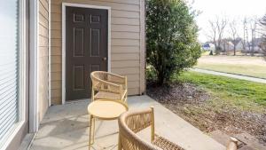 een veranda met 2 stoelen, een tafel en een deur bij Landing Modern Apartment with Amazing Amenities (ID8089X06) in Louisville