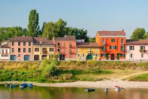 a group of buildings on the river with boats in the water at 149 BORGO TICINO SUITE Attico di Lusso con Terrazzo e Parking Privato in Pavia