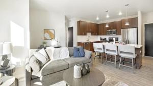 a living room with a couch and a kitchen at Landing Modern Apartment with Amazing Amenities (ID1231X251) in Saint Paul