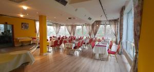 フレールスハイムにあるFlörsheimer Hofの白いテーブルと赤い椅子が備わるレストラン