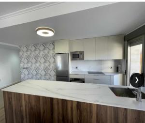 uma cozinha com uma grande bancada branca num quarto em Clauadris Home ideal para familias em Águilas