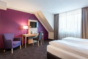 a hotel room with a bed and a desk and chair at Die Post Hotel in Bad Grönenbach