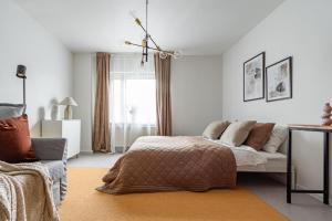 1 dormitorio con cama, sofá y ventana en Modern Charm Stylish Studio in Sodermalm en Estocolmo