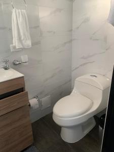a bathroom with a white toilet and a sink at Hermosa Casa Central - Rositas's house in La Mesa