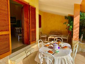 a table with plates of food on it on a patio at Casa Greta in Costa Rei