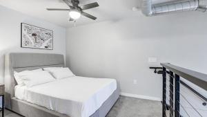um quarto branco com uma cama e uma ventoinha de tecto em Landing Modern Apartment with Amazing Amenities (ID1182X212) em Saint Paul