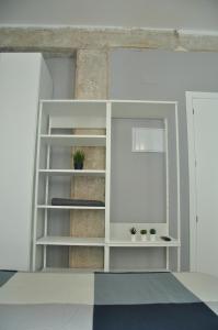 uma estante de livros branca com vasos de plantas sobre ela em La Casa Verde - Ruzafa em Valência