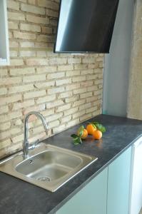 a kitchen counter with a sink and some oranges at La Casa Verde - Ruzafa in Valencia