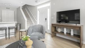 uma sala de estar com uma televisão e uma cadeira em Landing Modern Apartment with Amazing Amenities (ID1263X661) em New Albany